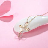 Delicate dainty gold necklace with ribbon inspired cross design